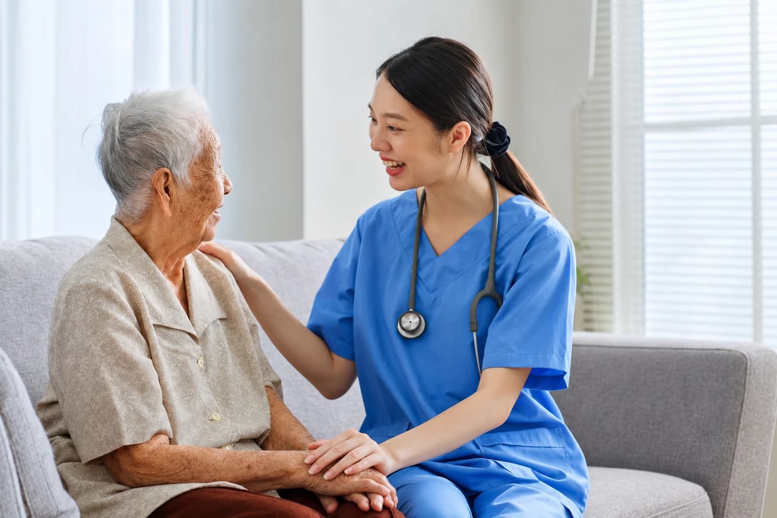 Điều dưỡng trò chuyện và nắm tay người cao tuổi
