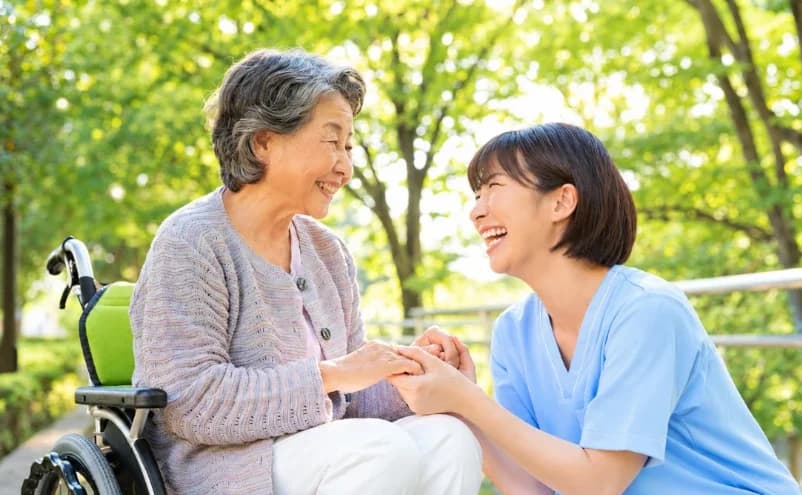 Nhân viên chăm sóc nắm tay người cao tuổi